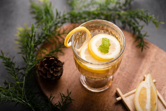Glass of Gin Drink with Lemon Slices in Holiday Decoration