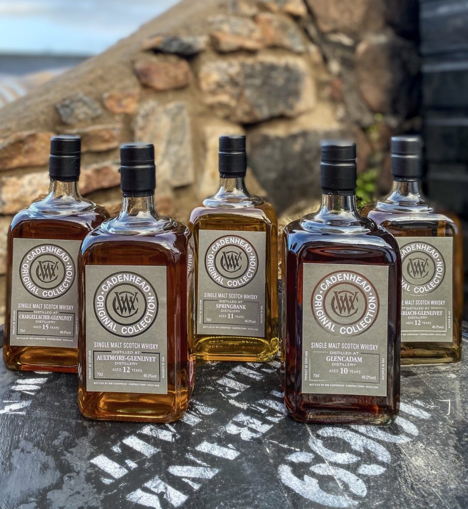 A collection of Wm Cadenhead's bottles, featuring a variety of whiskeys, gins, and rums from Scotland's oldest independent bottler.