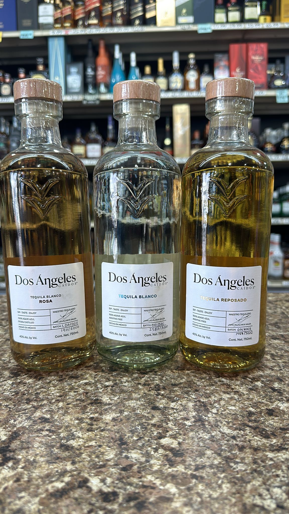 Dos Angeles Tequila 3 Bottle Combo featuring Blanco, Rosa, and Reposado varieties with elegant labels in a liquor store setting.